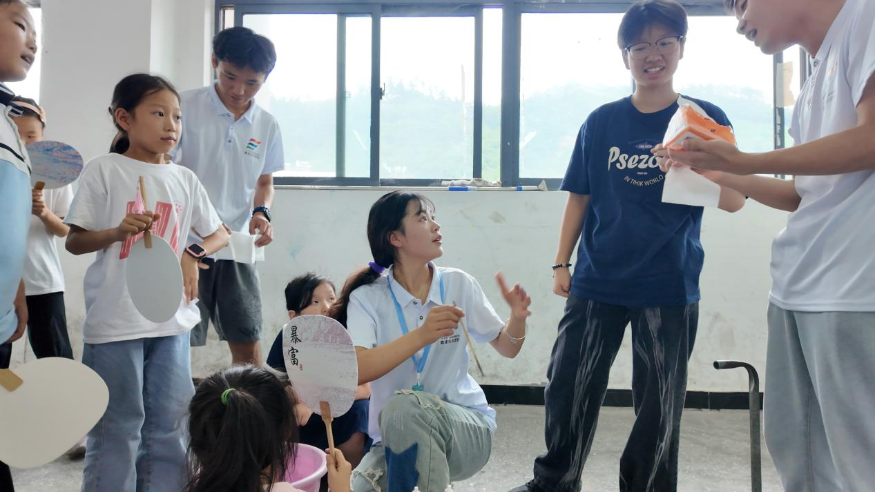 团队成员带小朋友们做漆扇。张先瀛 摄.png